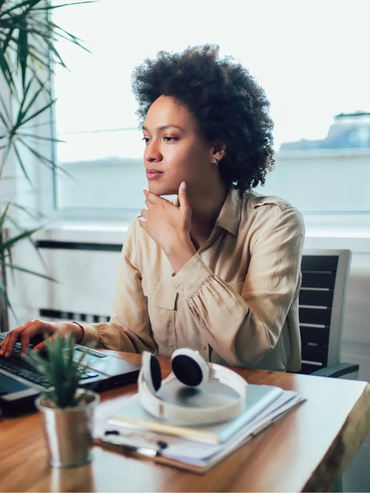 Femme travaillant et souriant : représentation positive de la réalité qu'est entreprendre après un burn-out.